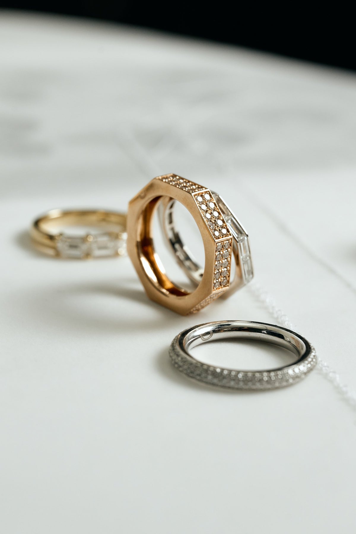 Close-up of a rose gold octagonal pavé ring and a white gold baguette ring, with a white gold pavé lab-grown diamond band - Daure collection