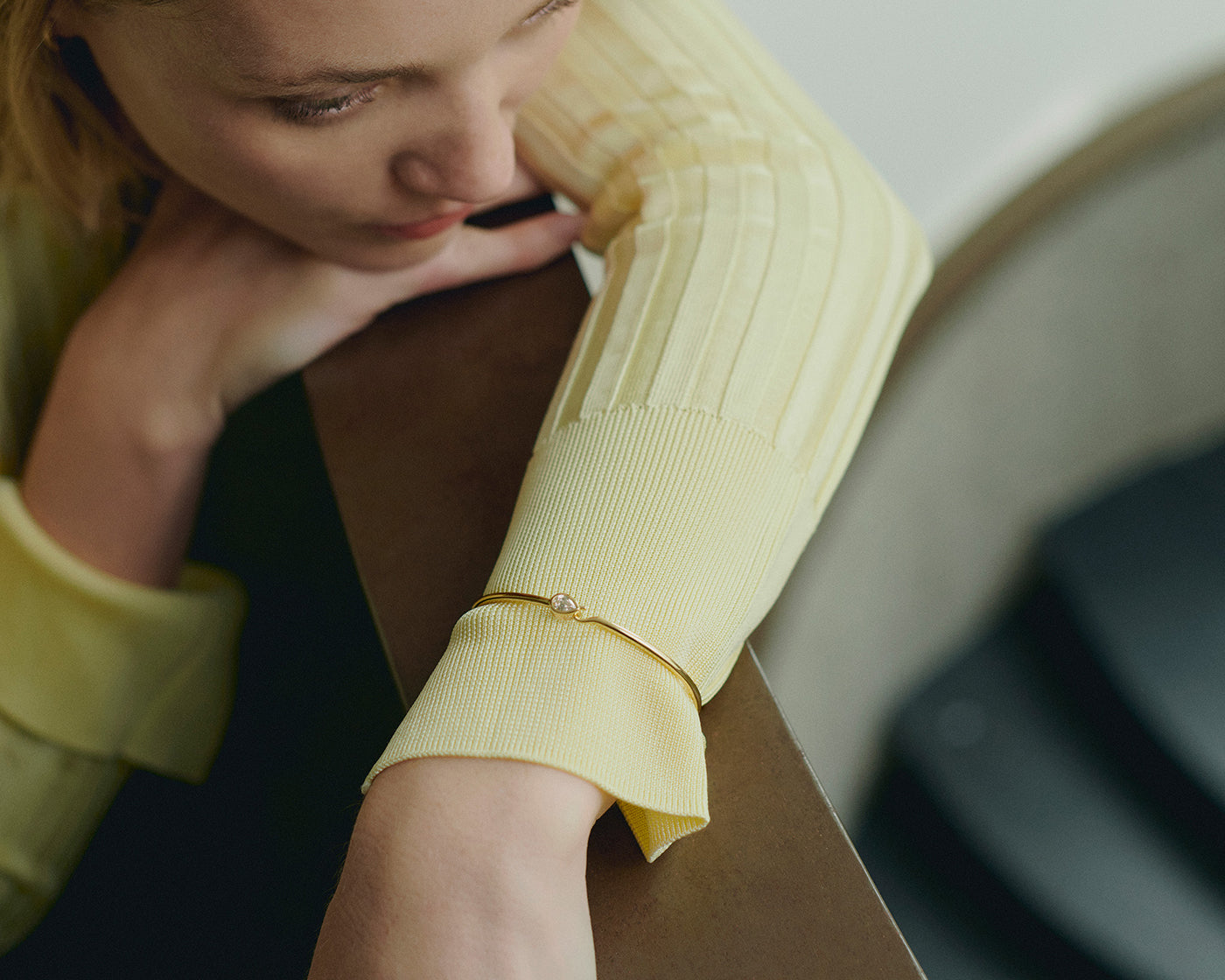 Yellow gold thin bangle bracelet with pear-cut diamond worn on wrist - Daure collectio