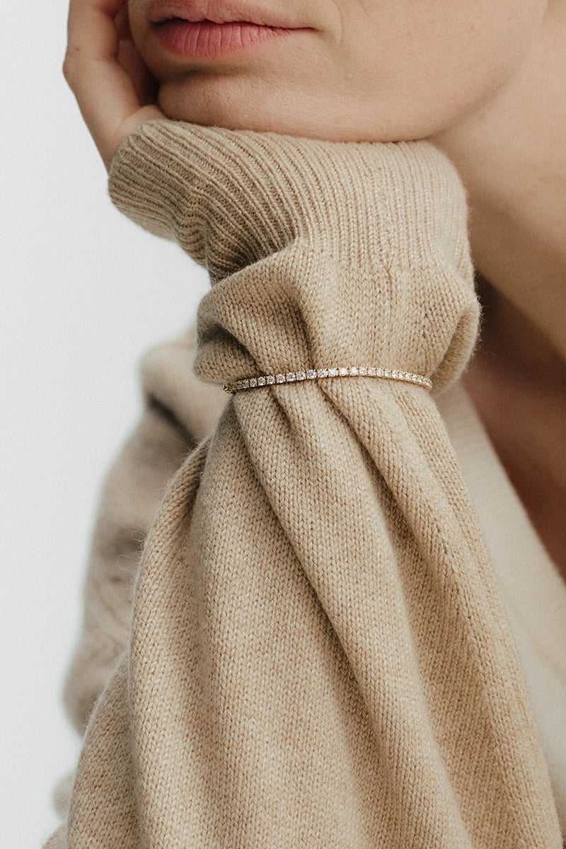 Brili tennis bracelet in yellow gold with lab-grown diamonds worn over a beige knit sleeve - Daure collection